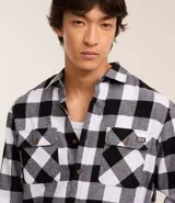 Camisa de franela a cuadros rojos y negros, de corte regular, manga larga y cuello inglés.