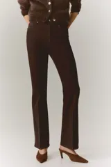 Jean de corte bootcut y tiro alto en color marrón oscuro, con diseño de cinco bolsillos y raya marcada en el frente y la espalda.