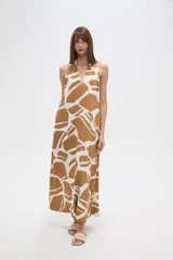 Vestido largo de corte holgado con estampado geométrico en tonos verde oliva y blanco. Presenta cuello en V, diseño sin mangas y bolsillos laterales.