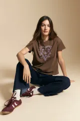 Remera de manga corta color marrón, con estampado central de corazón en color lila.
