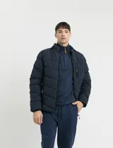 Campera capitoneada de poliéster color negro, con capucha desmontable, cierre frontal y bolsillo en el pecho con cierres engomados y tiradores en color naranja.