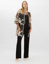 Conjunto de tres piezas compuesto por una musculosa negra con escote en V, un pantalón palazzo de tejido de punto liso con cintura elástica y una túnica larga de tul negro con mangas 3/4. La túnica presenta un bordado floral detallado con aplicaciones de lentejuelas.