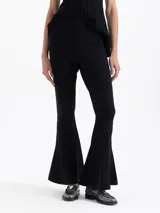 Pantalon de tejido de punto color negro, con ajuste al cuerpo y botamanga ancha acampanada con detalle de plisado vertical.