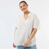 Blusa blanca de gasa de algodón, con cuello fruncido, escote en V con cierre frontal de botones y mangas cortas abullonadas.
