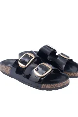 Sandalia tipo birkenstock negra de charol brillante, con dos tiras ajustables y hebillas doradas. La suela es gruesa con borde de apariencia corcho.