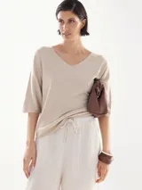 Remera de lurex color beige con escote en V y mangas cortas.