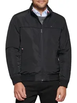 Campera bomber Tommy Hilfiger negra de poliéster, con cuello alto, cierre frontal con cremallera, dos bolsillos laterales con cremallera, puños elásticos y logo bordado en el pecho.