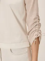 Remera de manga larga color blanco con cuello redondo y detalles fruncidos con lazos en las mangas.