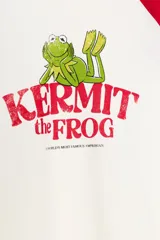 Camiseta de manga larga con cuello redondo, corte regular fit. Color blanco con mangas raglán rojas. Estampado frontal de Kermit the Frog y el texto "Kermit the Frog" en rojo.