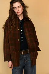 Chaqueta de mujer de la colección Zara Woman, confeccionada en algodón 100% con acabado encerado. Presenta un estampado a cuadros en tonos marrón y rojo, cuello solapa de pana, manga larga con puño y botón, bolsillos de plastrón con solapa en el delantero y cierre frontal con botones a presión.
