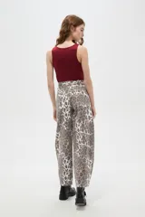 Pantalon tipo jean de corte barrel y tiro bajo, con estampado animal print de leopardo en tonos marrones y blancos.