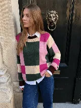 Buzo de punto con diseño de bloques de color en tonos verde, rosado, beige y bordó. Cuenta con mangas largas y cuello redondo.