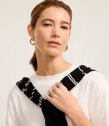 Blusa de manga corta confeccionada en algodón pima, con cuello redondo y diseño liso. Presenta un corte clásico con el bajo ligeramente más largo en la parte posterior.