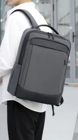 Mochila azul marino de tela con detalles en cuero sintético negro. Tiene dos asas acolchadas, compartimento para laptop, bolsillo frontal con cierre y un bolsillo lateral.