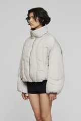 Campera tipo bomber acolchada, color negro, con cuello alto, cierre frontal con cremallera y diseño de mangas amplias.