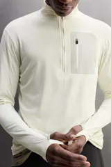 Camiseta de manga larga negra, confeccionada en tejido técnico ligero y elástico. Tiene cuello alto con cremallera, corte slim fit, bolsillo frontal con cremallera y puños con cinta a contraste.