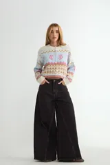 Jean de corte wide leg con diseño de costuras verticales decorativas en el frente, tiro medio y cierre frontal con botón y cremallera.