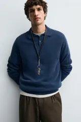 Polo de punto de corte regular fit, confeccionado en una mezcla de lana y cashmere. Presenta cuello solapa con cierre frontal de dos botones, manga larga y terminaciones en rib.