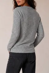 Sweater tejido de punto melange color bordó, con escote en V y mangas largas.