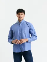 Camisa de manga larga en color azul, con cuello abotonado y bolsillo frontal en el pecho.
