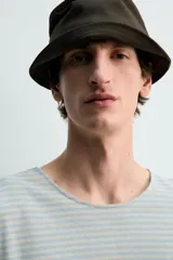 Camiseta de manga larga con ajuste relaxed fit y cuello redondo amplio, confeccionada en tejido de mezcla de algodón y lino con patrón de rayas horizontales en color verde y blanco.