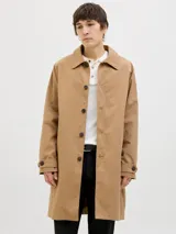 Campera tipo trench coat de corte recto y largo medio, color tostado. Presenta cuello camisero, cierre frontal con botones oscuros y puños ajustables con trabilla y botón.
