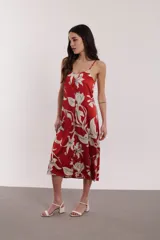 Vestido midi rojo con estampado floral blanco, de breteles finos y corte recto.