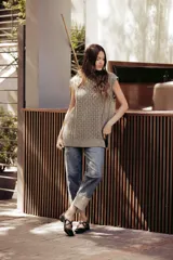 Chaleco de punto color beige, con cuello redondo, sisa amplia y corte relajado. Presenta un tejido texturizado con patrones geométricos.