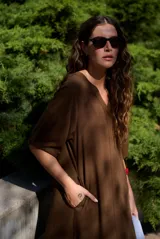 Vestido midi de corte recto, color marrón en la parte superior y marrón rojizo en el inferior con detalle de franjas horizontales superpuestas. Cuenta con escote en V y mangas cortas holgadas.
