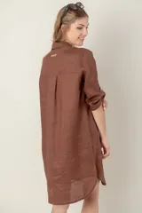 Vestido camisero corto de lino color celeste, con cuello clásico, cierre frontal con botones, mangas 3/4 con trabillas y bolsillo de parche en el pecho con bordado de iniciales.