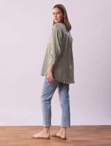 Blusa verde con rayas verticales blancas, cuello en V con botones y mangas 3/4 con puño y botón.