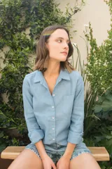 Camisa celeste de lino con cuello clásico, manga larga con puños abotonados, cierre frontal con botones y bolsillo en el pecho. Presenta bordado floral en la espalda.