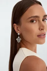 Aros colgantes plateados con diseño de abanico, decorados con pedrería de cristales facetados en tonos transparentes.