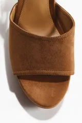 Sandalias de plataforma con acabado de gamuza sintética color tostado, punta redondeada, tira ancha en el empeine, pulsera ajustable con hebilla metálica dorada y taco de bloque alto forrado.