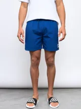 Short de baño azul con cordón ajustable en la cintura y logo de la marca Umbro en la pierna derecha.