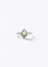 Anillo de plata 925 con piedra central en forma de gota de color verde oliva, rodeada de zirconias cúbicas pavé y zirconias engastadas en los laterales del aro.