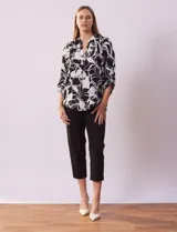 Blusa de gasa estampada con flores rojas y blancas, marca Floral & Ivy. Tiene cuello a la base con escote en V y mangas tres cuartos regulables con presilla y botón.