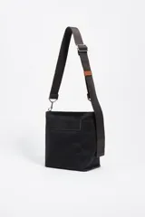 Bolso bandolera de tamaño pequeño en color verde oliva, confeccionado en poliamida con detalles en piel vacuna. Cuenta con asa larga regulable de tejido en color negro, cierre superior con cremallera y logo de la marca estampado en la parte frontal.