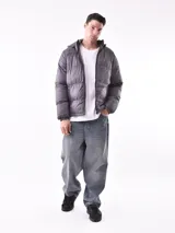 Campera puffer gris con capucha, cierre frontal completo y puños elásticos.