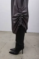 Falda larga color gris plomo de poliéster con spandex, cintura elastizada y frunces laterales regulables.