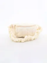 Riñonera acolchada celeste con correa ajustable y cierre superior con dije de flor.