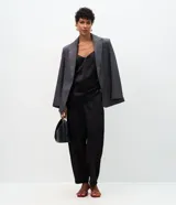 Pantalón wide leg de corte sastrero confeccionado en tejido satinado con caída fluida. Presenta cintura con presillas, cierre frontal oculto y diseño de piernas amplias.