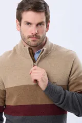 Buzo tejido de punto con diseño de rayas horizontales en tonos verde, gris y azul. Presenta cuello alto con cierre frontal parcial y detalle en material tipo gamuza en la solapa del cierre.