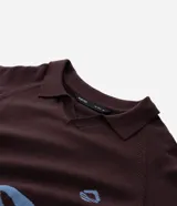 Suéter de punto en jacquard color bordó con diseño de cuello polo y cierre frontal parcial. Presenta estampado frontal con la palabra 'EASY' y la frase 'plans being' en color celeste, además de un pequeño logo bordado. Posee mangas largas con puños acanalados y un corte holgado.