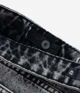 Pantalón de jean con corte recto y efecto desteñido, caracterizado por sus bolsillos cargo funcionales en los laterales y pences en las rodillas. Presenta un diseño utilitario y moderno con cierre frontal y bolsillos clásicos.