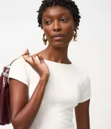 Blusa de corte peplum confeccionada en tejido Punto Roma, con escote redondo, mangas cortas y recortes estructurados que definen la silueta.