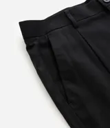 Pantalón de sastrería color negro, de corte recto y fluido. Presenta cintura estructurada con trabillas, cierre frontal con botón y cremallera, pliegues delanteros y bolsillos laterales funcionales.