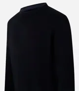 Suéter negro de tejido de punto pesado, con cuello redondo y mangas largas.