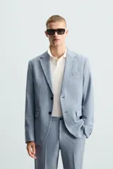 Blazer de corte slim fit confeccionada en tejido con lana, con cuello de solapas de muesca, cierre frontal de un botón, bolsillos laterales con solapa y bolsillo de vivo en el pecho.