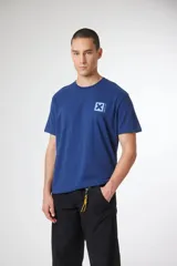 Remera de manga corta color azul, con cuello redondo y estampa pequeña en el pecho con forma de cruz y caracteres japoneses.